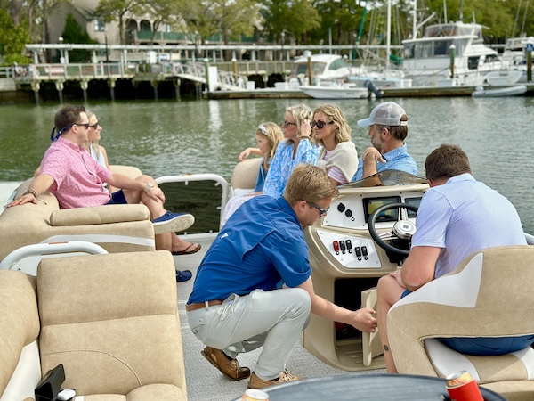 a group of people sitting on the pontoon ready to leave the marina