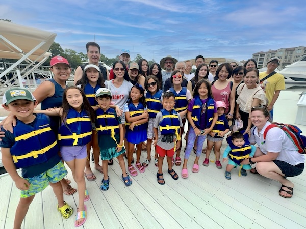 a group of people posing for the camera in front of a pontoon