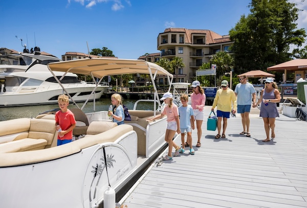 a group of people boarding a pontoon boat